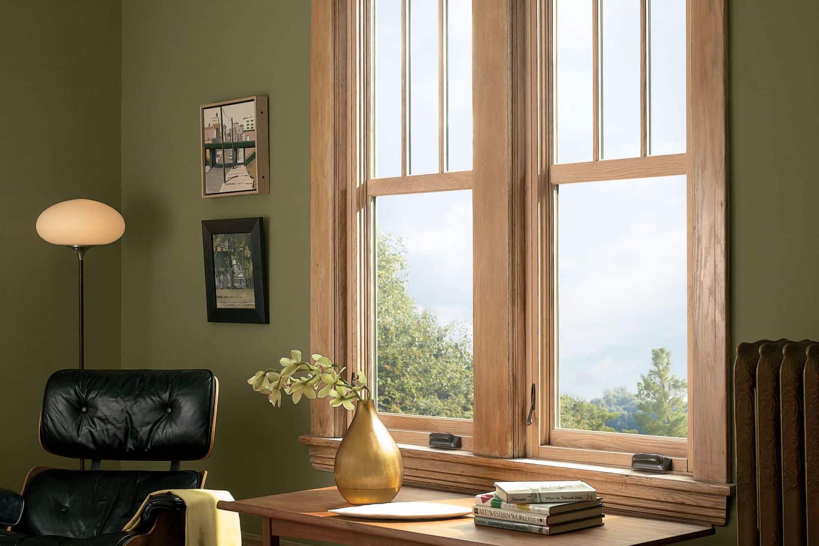 A home office corner with wooden ultimate case window frames.