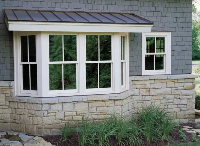 A contemporary home features ultimate bay windows available for purchase and installation at MNRC Inc.